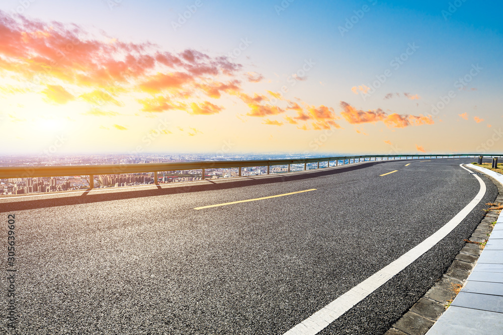 Shanghai city skyline and empty asphalt road scenery at sunset.