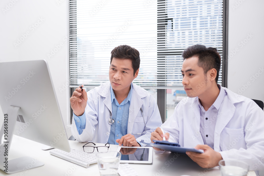 Hardworking doctors reviewing patients file