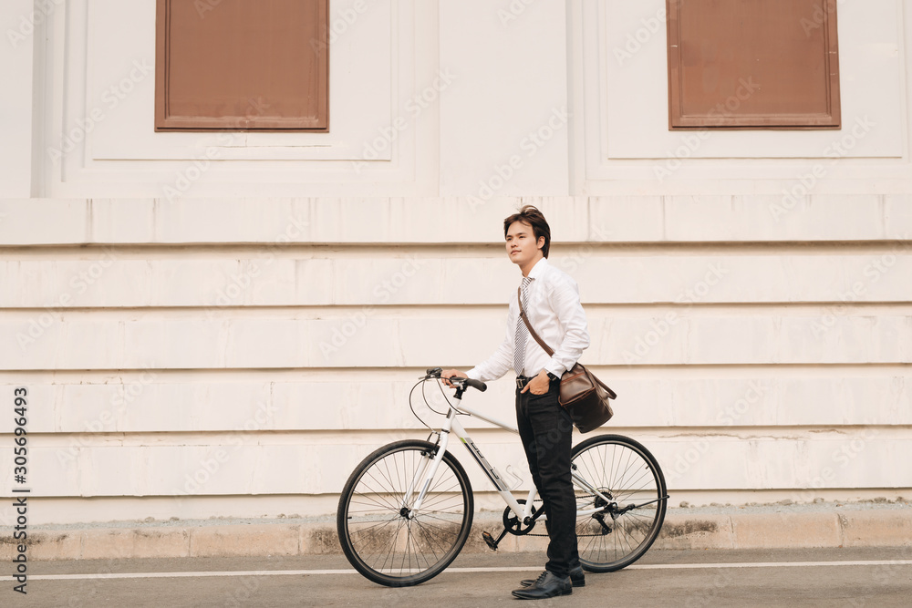 Outdoor portrait of handsome young man with fixed gear bicycle in the street.