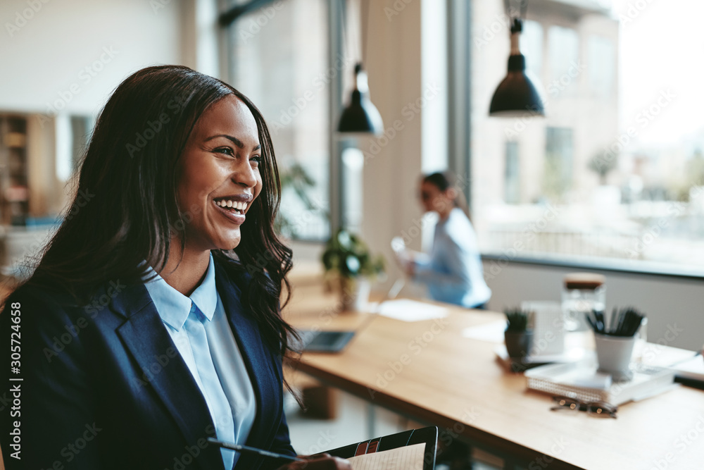 Laughing young African American businesswoman walking through an