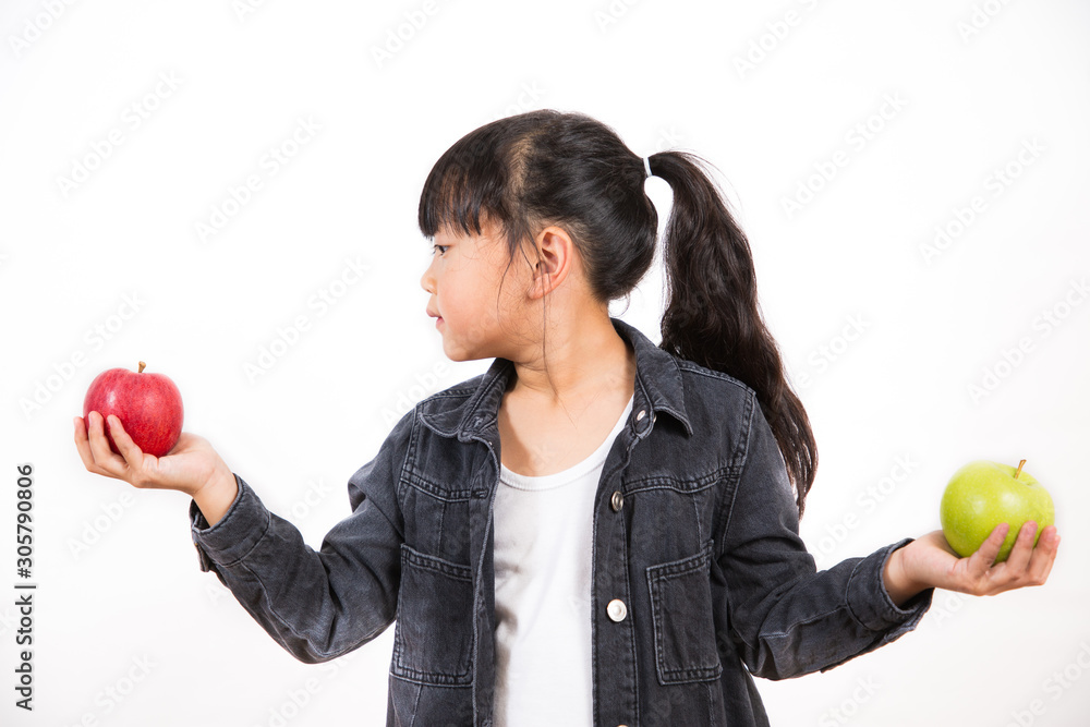 The image of an Asian girl holding a red and green apple in his hand is healthy and good for a white