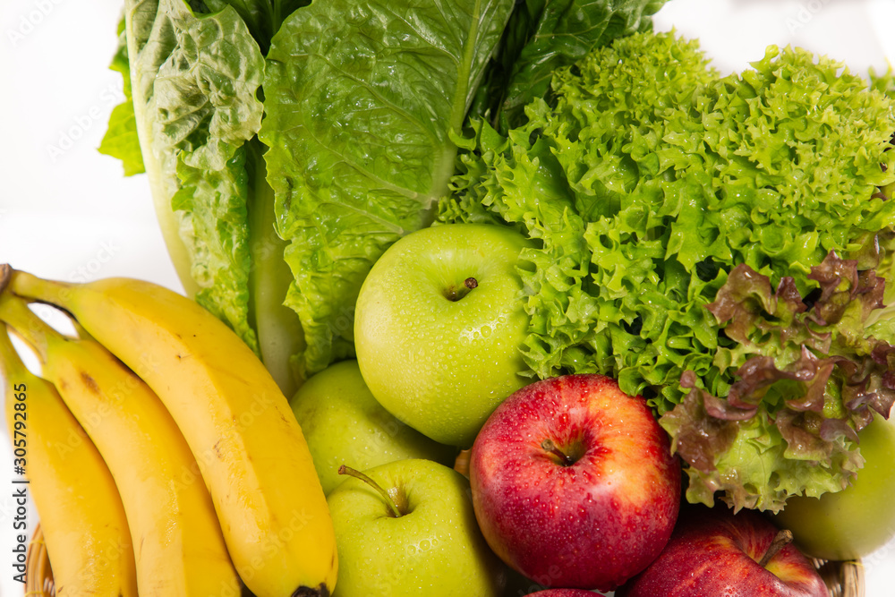 Bio-organic salad vegetables, apples, bananas in a basket. Good for health. Diet in the white backgr