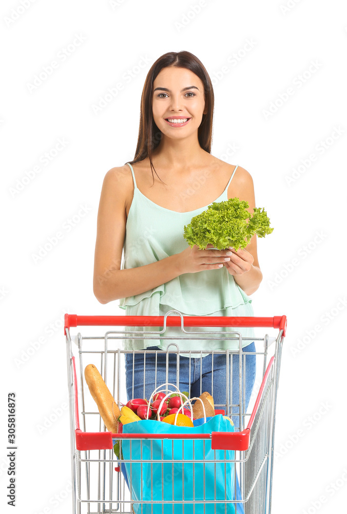 Young woman with shopping cart on white background