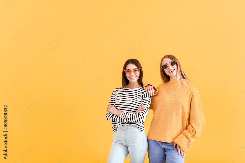 Stylish women on color background