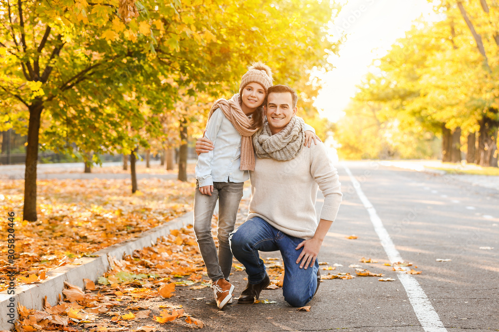 Portrait of happy father and little daughter in autumn park