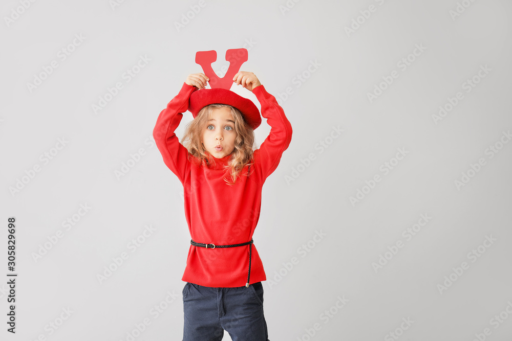 Cute little girl with red letter on grey background