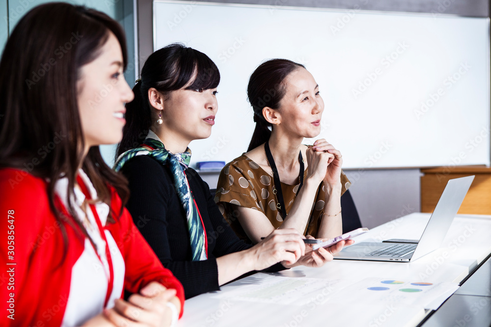 会議に出席する女性社員