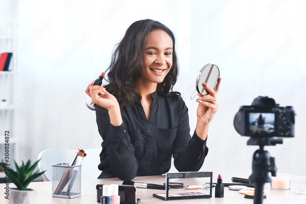 Young African-American beauty blogger recording video at home