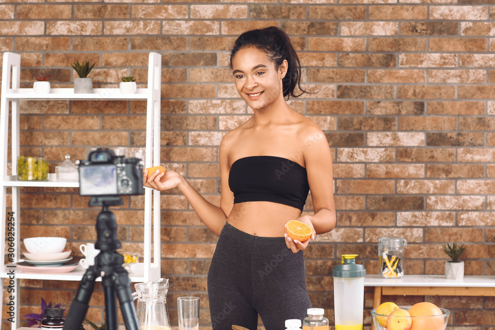 African-American blogger recording video about sport and healthy food at home