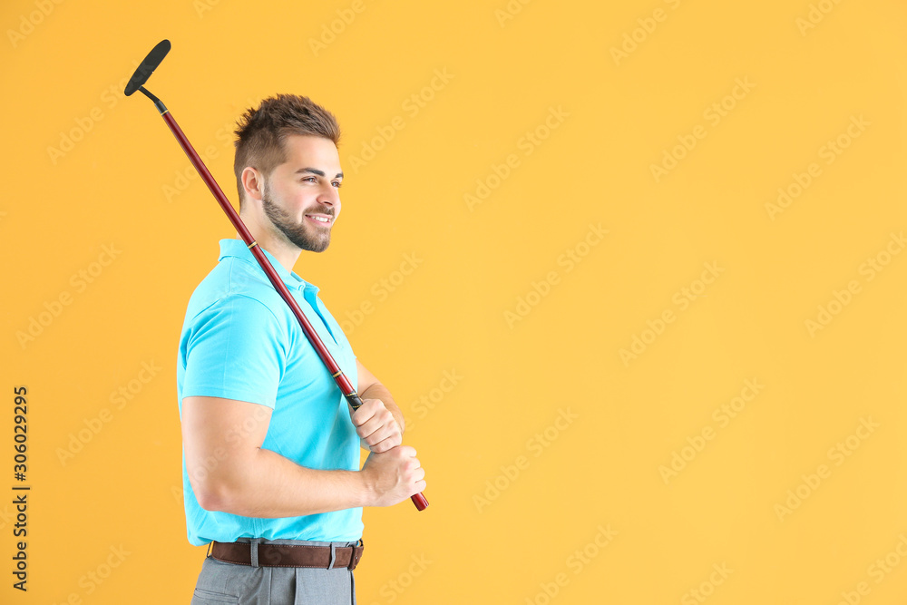 Handsome male golfer on color background