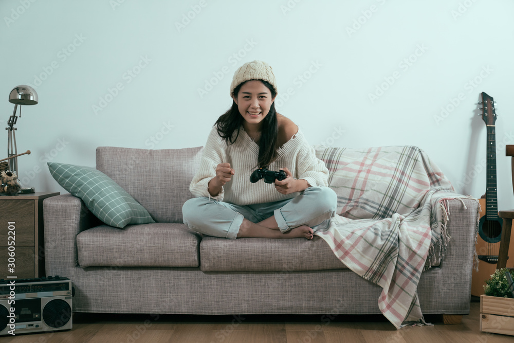 在白色墙壁背景下的温暖的冬天家里休息。美丽的年轻亚洲中国女人在玩耍