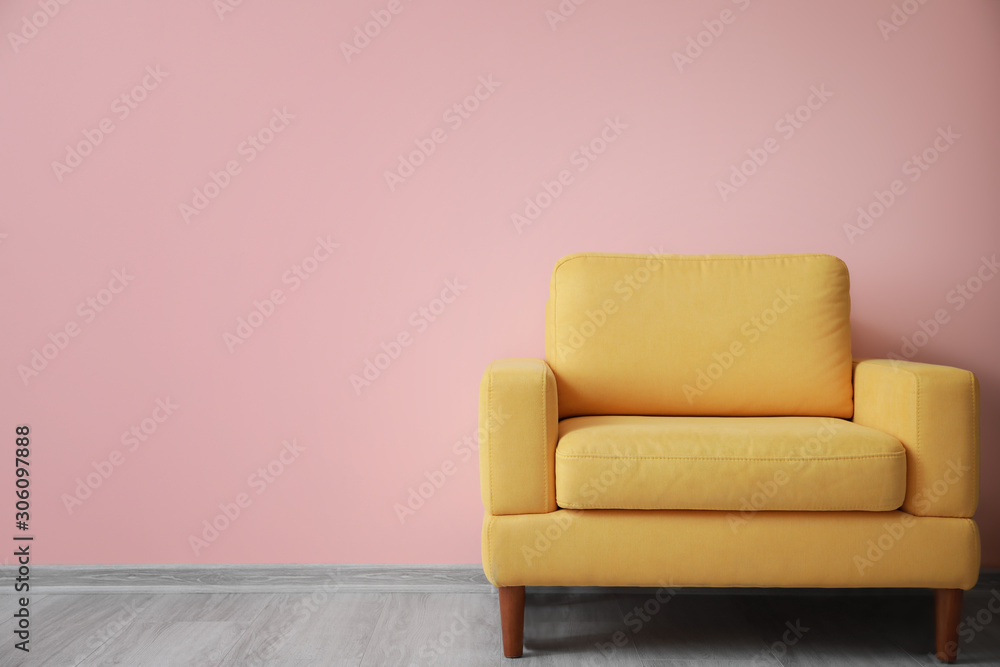 Stylish armchair near color wall