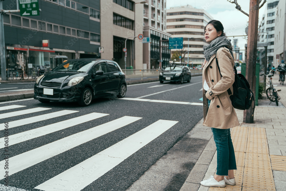 pretty asian chinese woman traveler walking in city osaka waiting for traffic lights to cross busy r