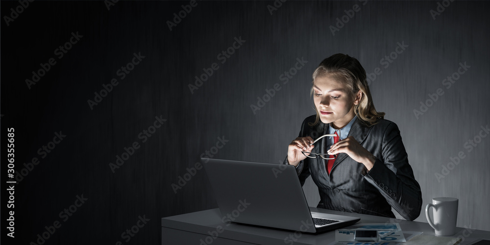 Charming businesswoman sitting at office desk