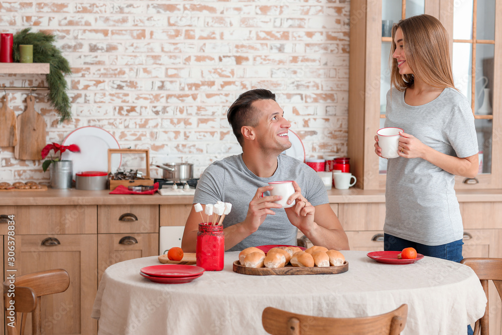 Happy young couple having breakfast on Christmas eve