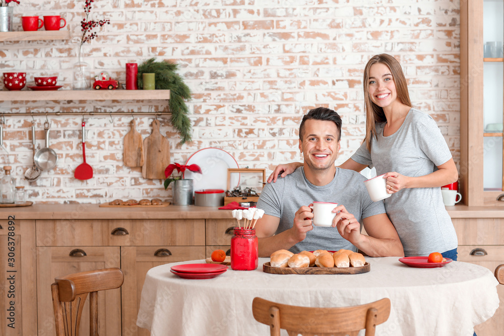 Happy young couple having breakfast on Christmas eve