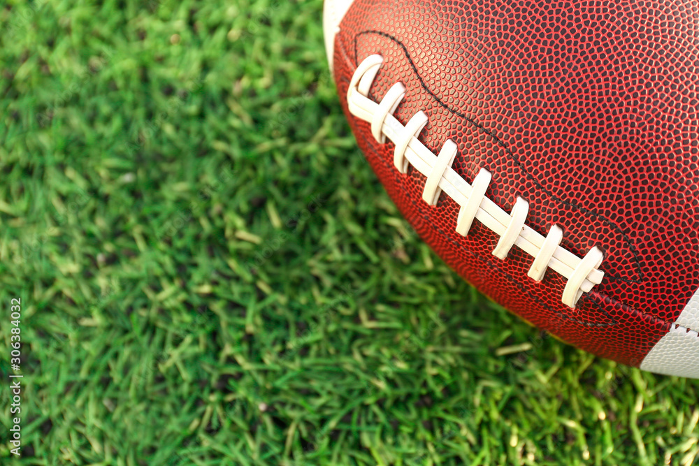 Rugby ball on green field outdoors, closeup