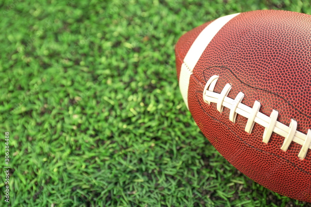 Rugby ball on green field outdoors, closeup