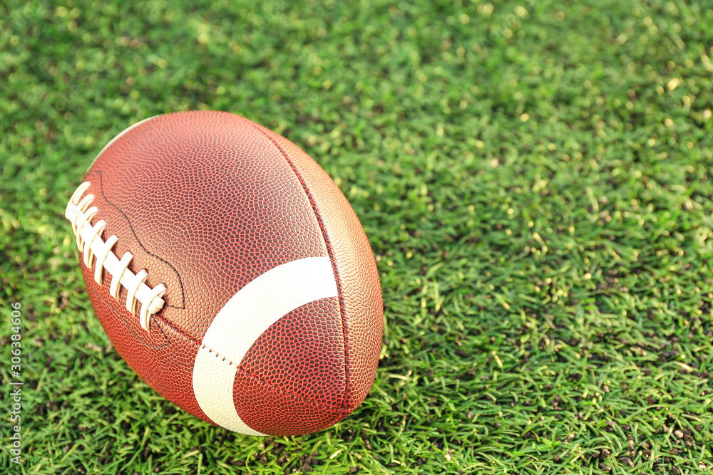 Rugby ball on green field outdoors