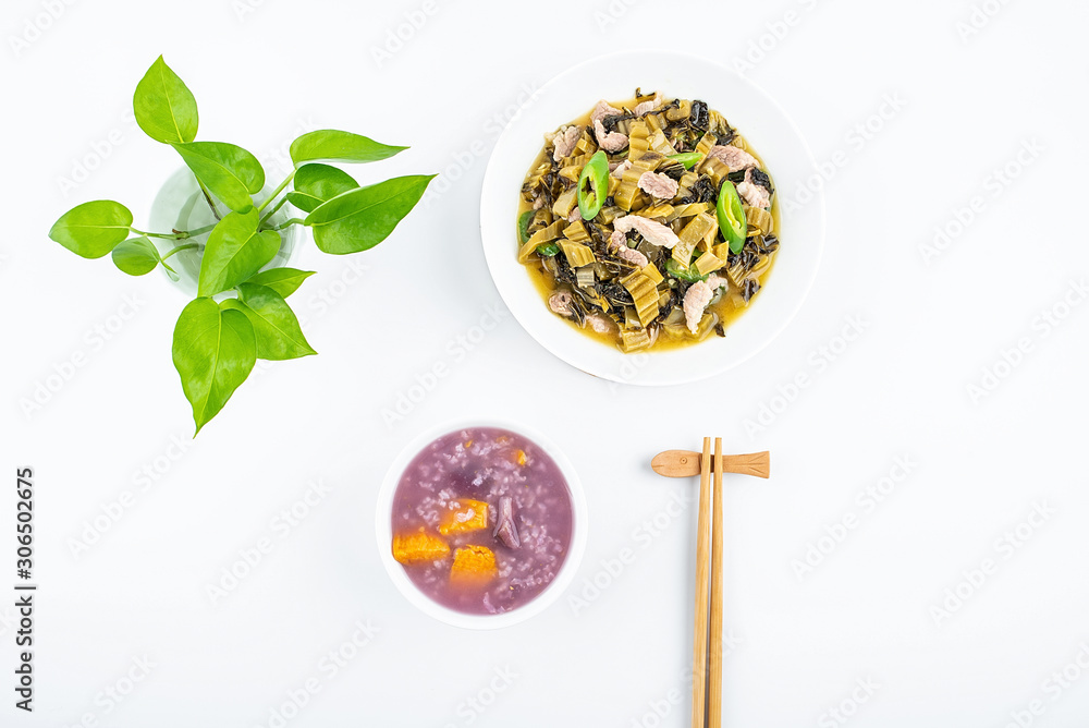 A dish of sauerkraut fried lean meat and a bowl of sweet potato porridge on white background