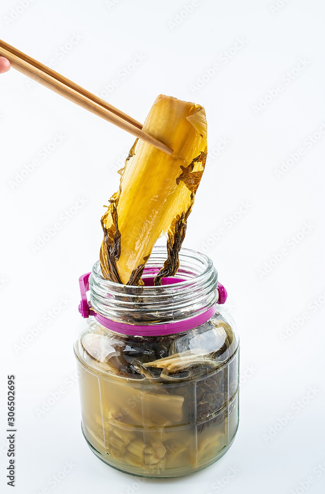 Pickled golden sour mustard with chopsticks on white background