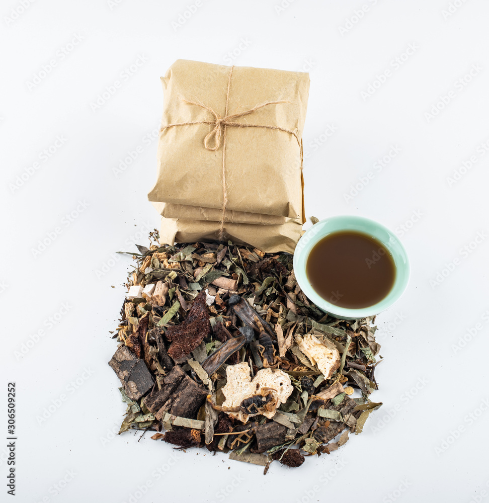 A pile of Chinese medicinal herbs and cooked soup on white background