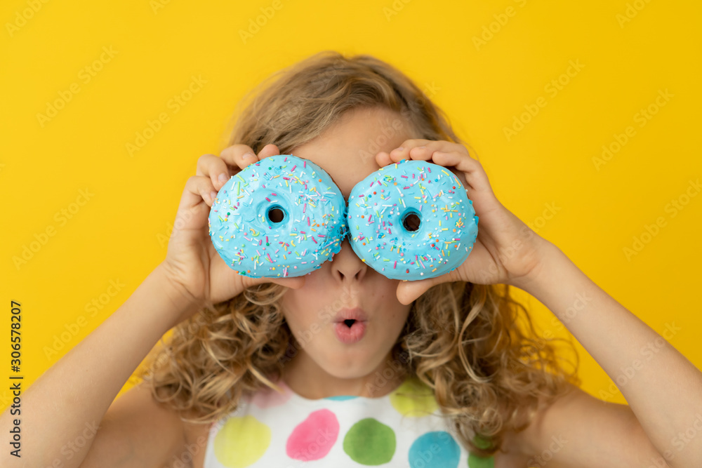 Happy child holding glazed donut