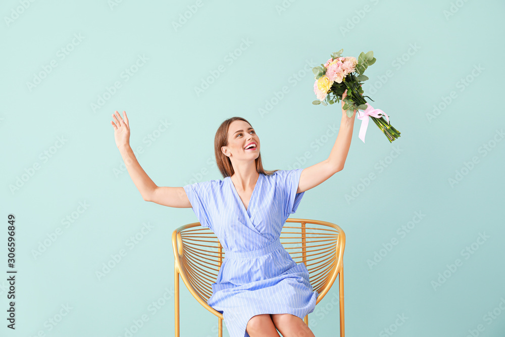 Beautiful young woman with bouquet of carnation flowers sitting in armchair on color background