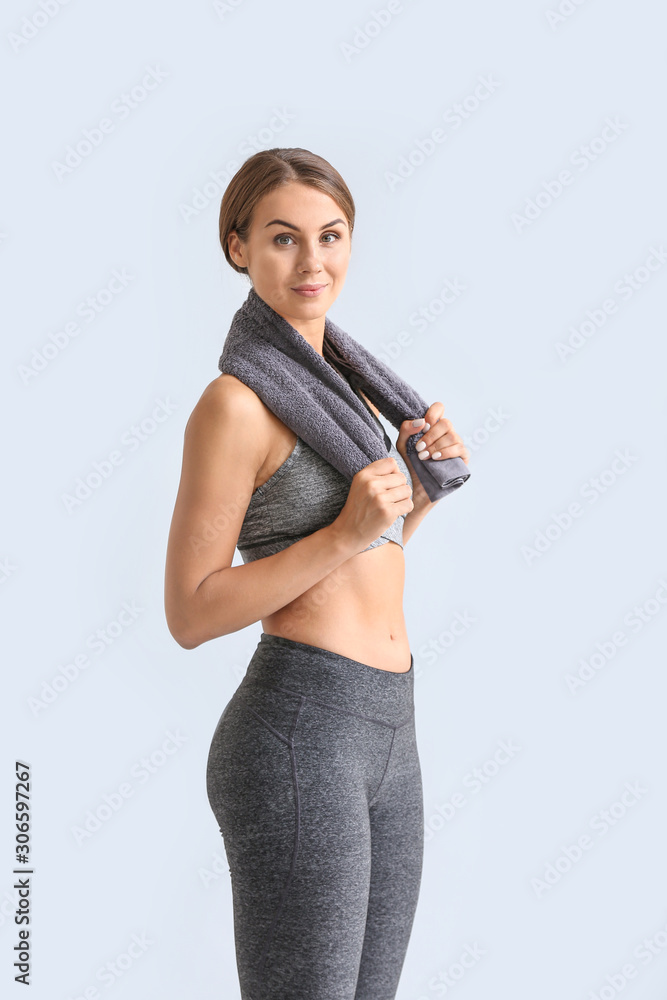 Sporty young woman on light background