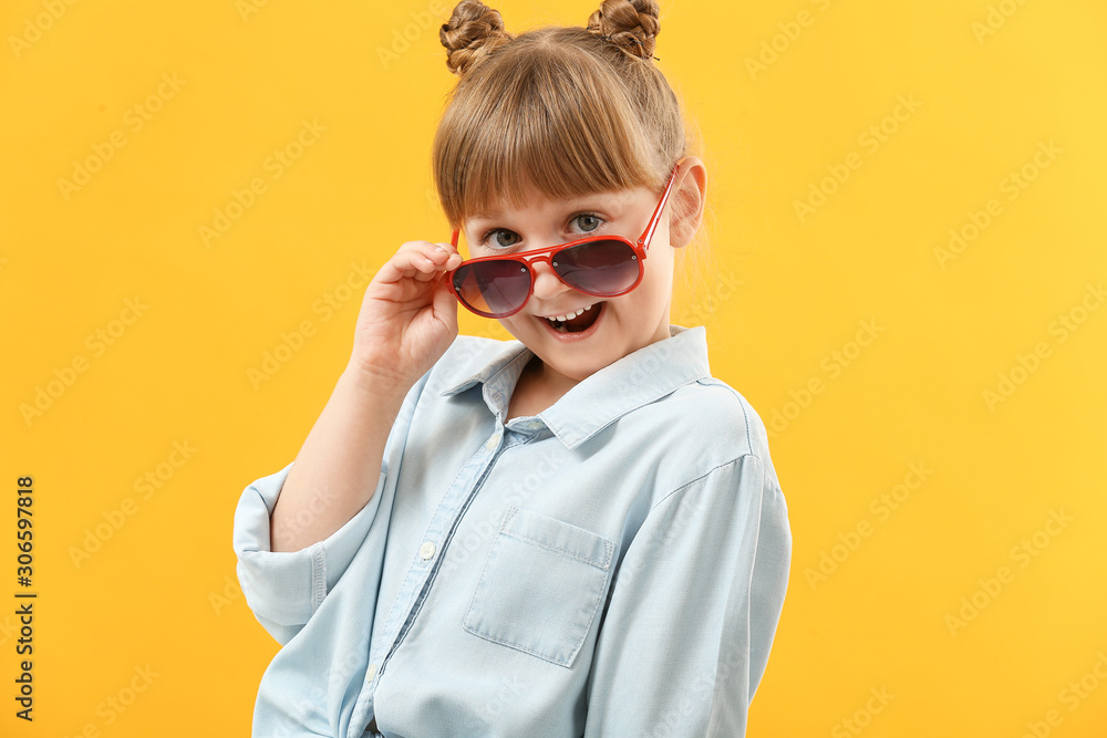 Portrait of stylish little girl on color background