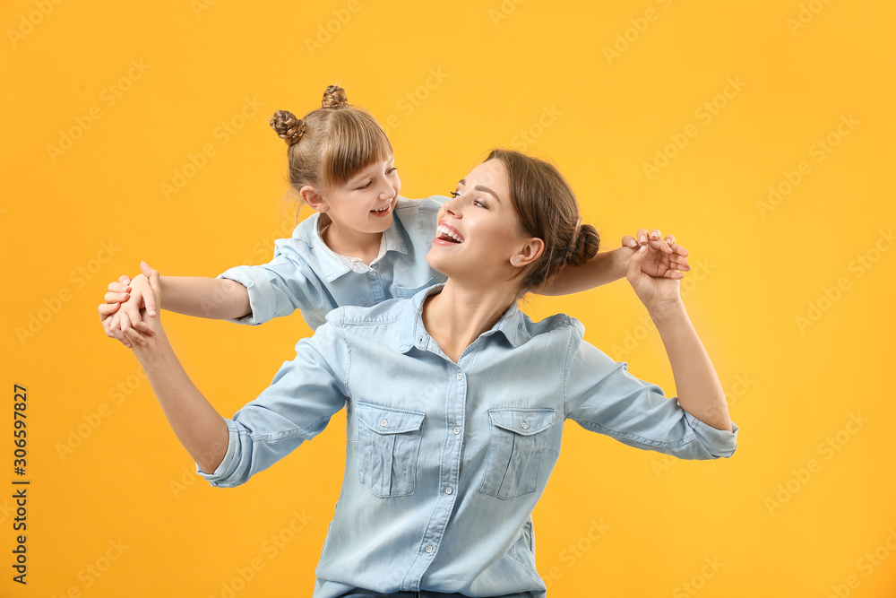 Portrait of happy mother and daughter on color background