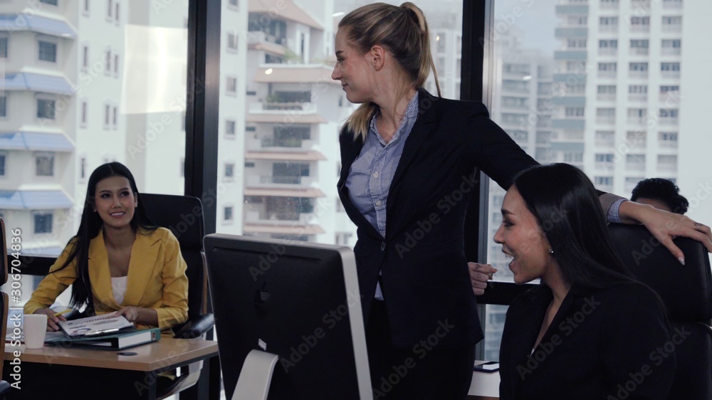 Young leader gives advice to young woman worker in modern office. Leadership and training concept.