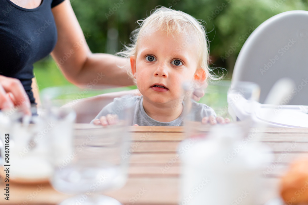 Cute baby child sitting at dinning table outdoor