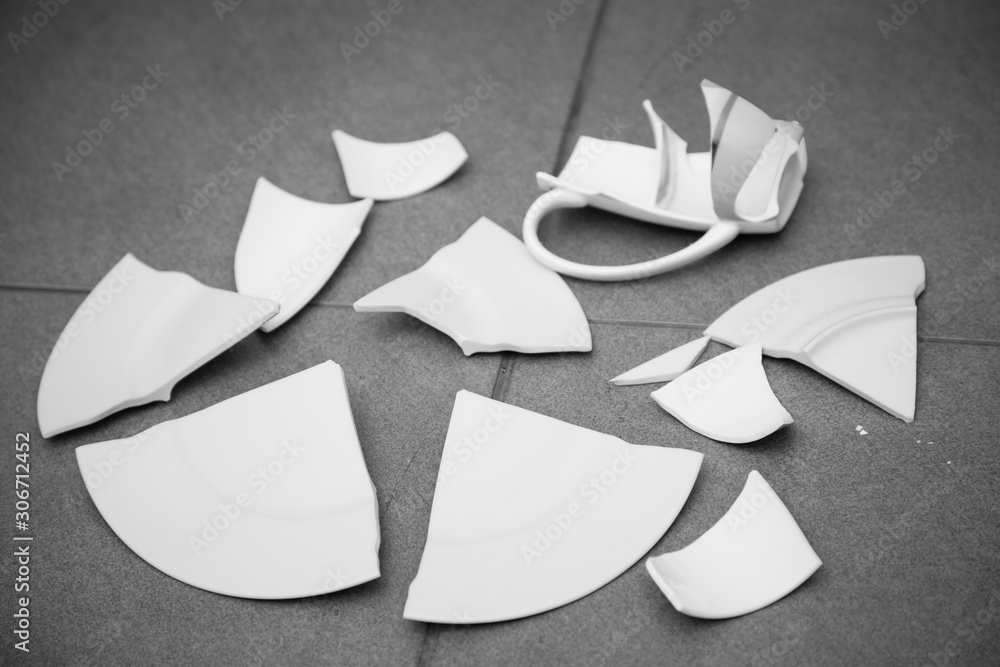 Broken white plate or Broken glass on the floor in the kitchen