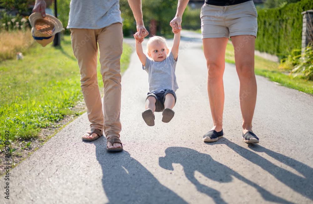 Happy family spending time together walking outdoor at sunny summer day