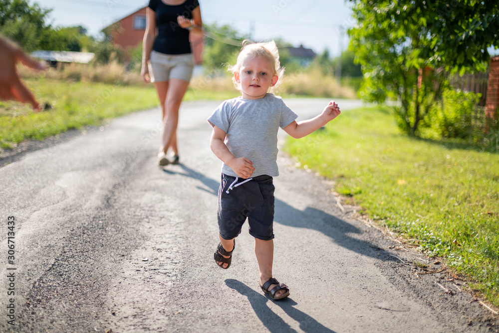 Happy family spending time together walking outdoor at sunny summer day