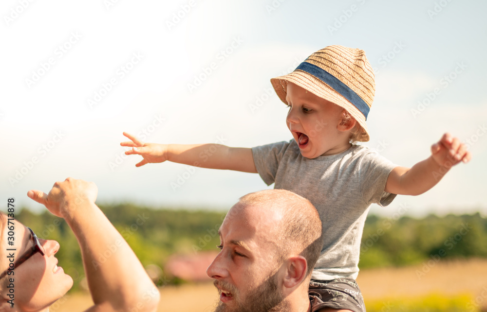 Happy family walking together with child on piggyback