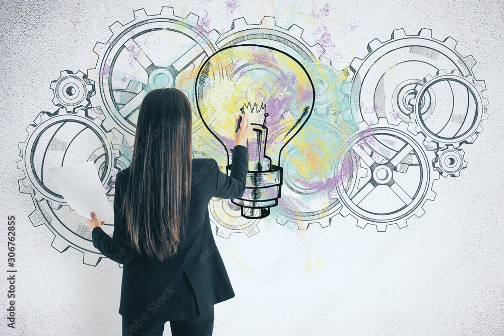 Businesswoman drawing cogs and lightbulb