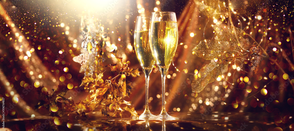 Holiday Champagne Flute over Golden glowing background. Christmas and New Year celebration. Two Flut