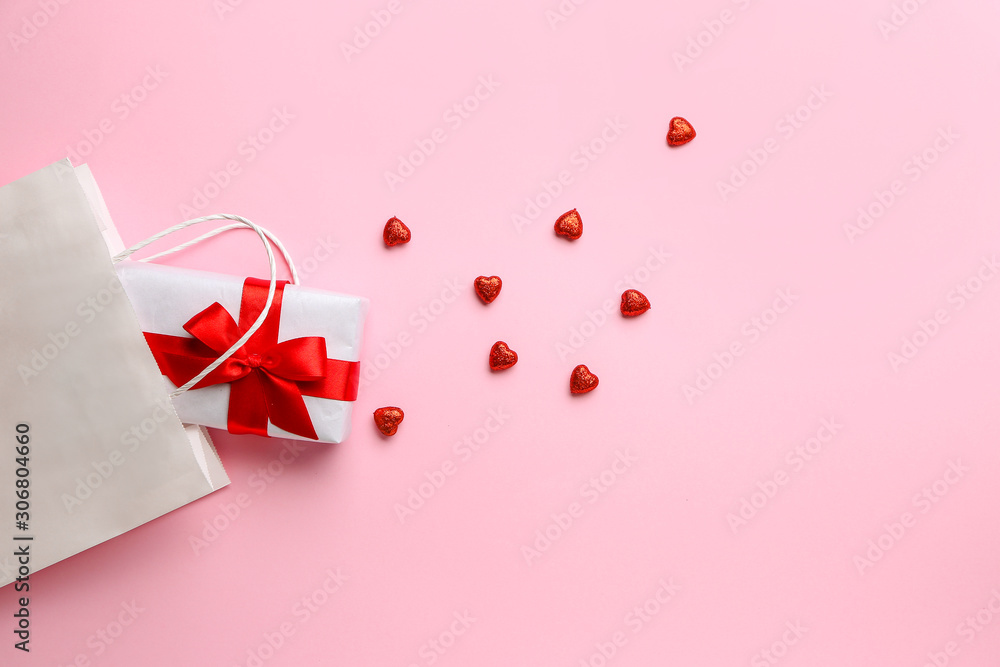 Gift for Valentines Day, bag and red hearts on color background