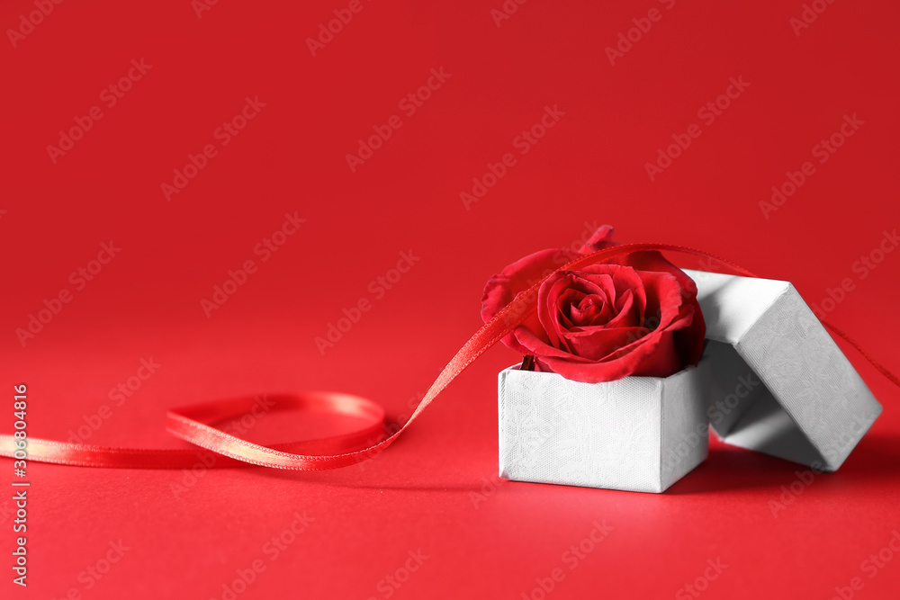 Box with rose flower on color background. Valentines Day celebration