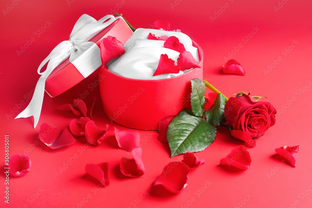 Beautiful rose and gift on color background. Valentines Day celebration