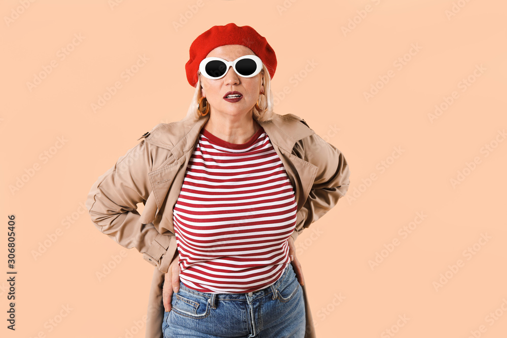 Fashionable mature woman on color background