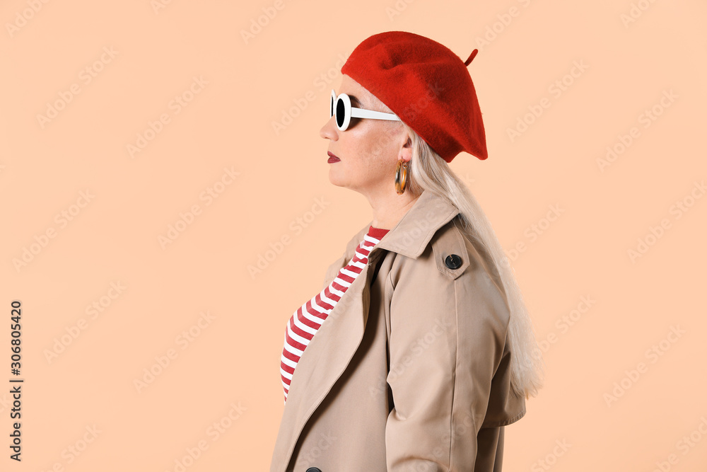 Fashionable mature woman on color background