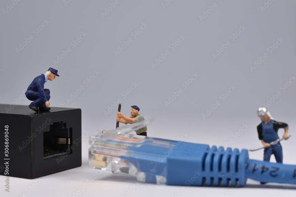 Mini workers are trying to fit a nethernet plug in a connector