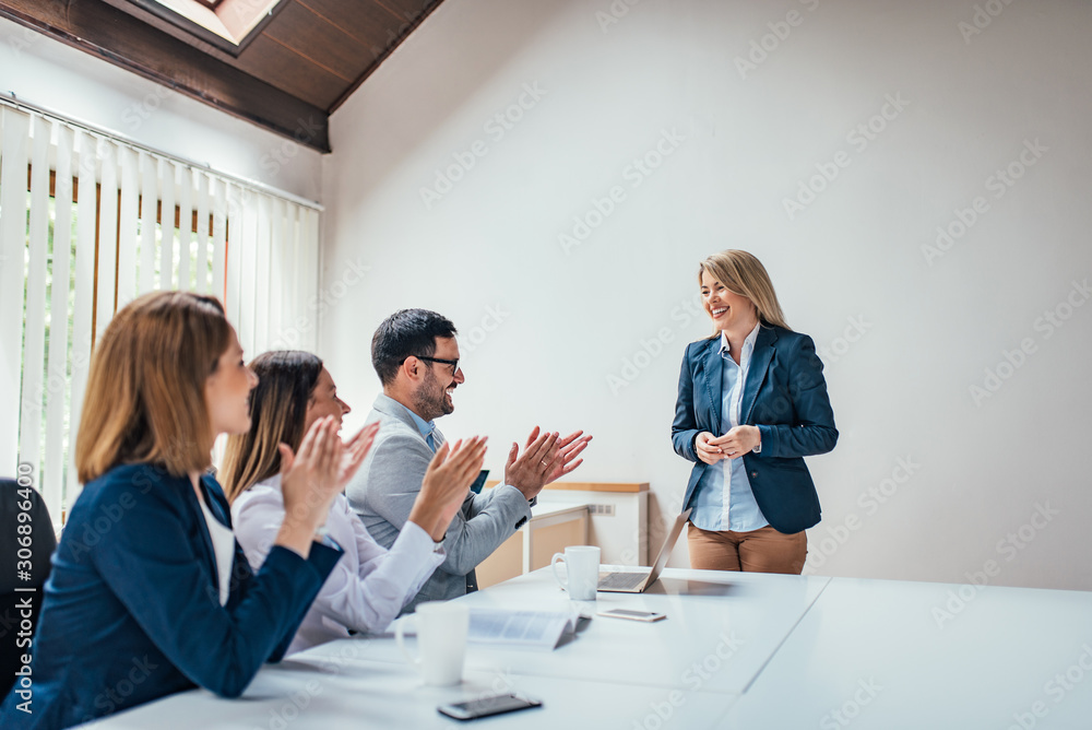 董事会会议桌上的商人在经理或高管的演讲后鼓掌。