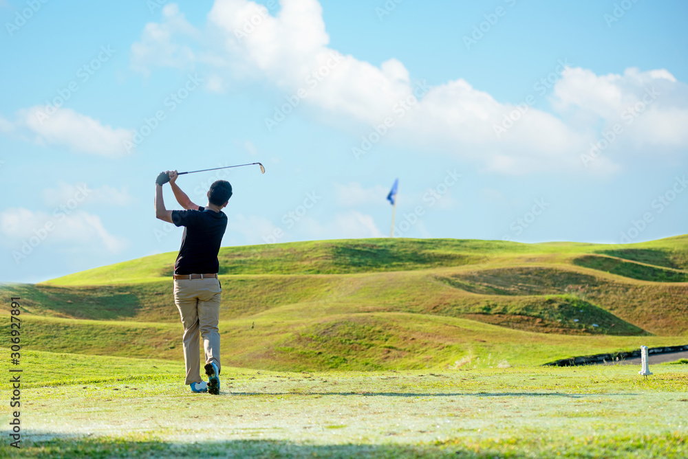 Professional golfer asian man approach on the tee off for swing and hitting golf ball and looking fa