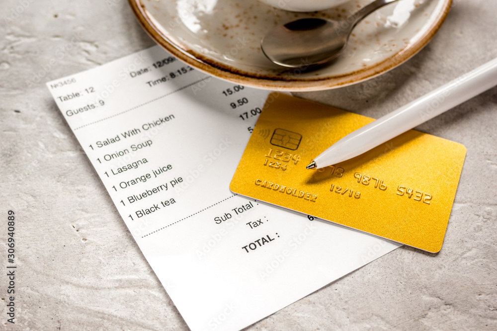 paying check for lunch in cafe with credit card on stone table background