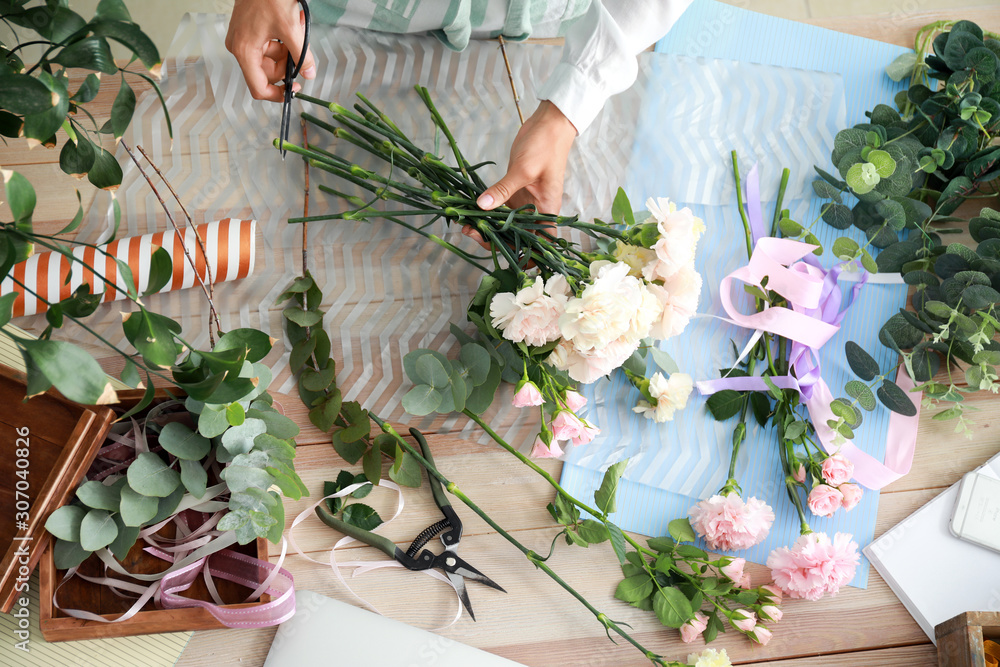 Female florist making beautiful bouquet in shop