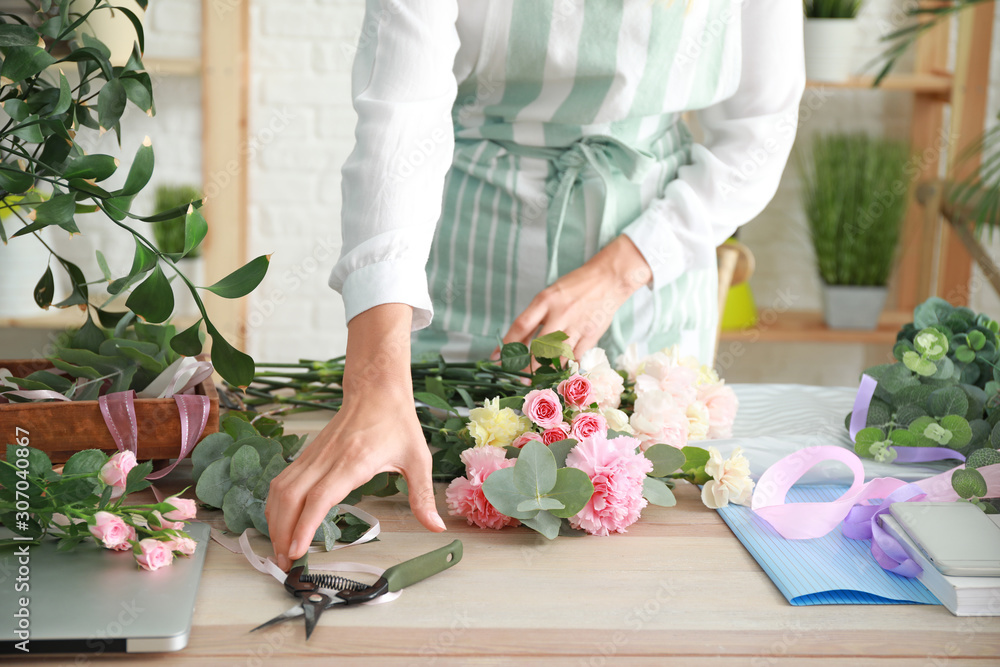 Female florist making beautiful bouquet in shop